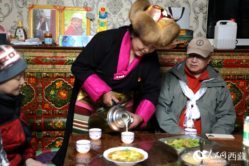 扎西曲登社區(qū)的居民在家中熱情招待遠(yuǎn)道而來(lái)的游客。居民身著盛裝，為游客倒上熱騰騰的酥油茶，桌上擺放著切瑪與特色美食，賓主共話民族團(tuán)結(jié)情誼。人民網(wǎng)記者 吳雨仁攝